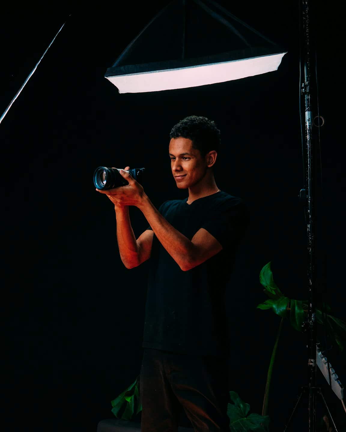 Un fotografo guarda attraverso il mirino della sua macchina fotografica in uno studio.